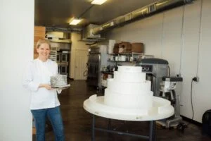 Melissa Samuels junto a la tarta de Minas Tirith creada por Melissa's Fine Pastries. Fotografía de GK Photography